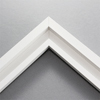 This simplistic yet modular white frame is designed for metal prints, acrylic prints and dry mounts. This smart design features a minimalist stepped profile that serves as a floater frame or a standard picture frame.
For the floating effect, the print can be attached on top of the inner step of the frame, without sacrificing the artwork edges.
This frame can also be used as standard picture frame. The lowered center paired with slightly raised outer lip creates a frame within a frame effect. However, due to the inner most lip of the frame, a fraction of the artwork will be hidden. But, this can be avoided with a linen liner combo.